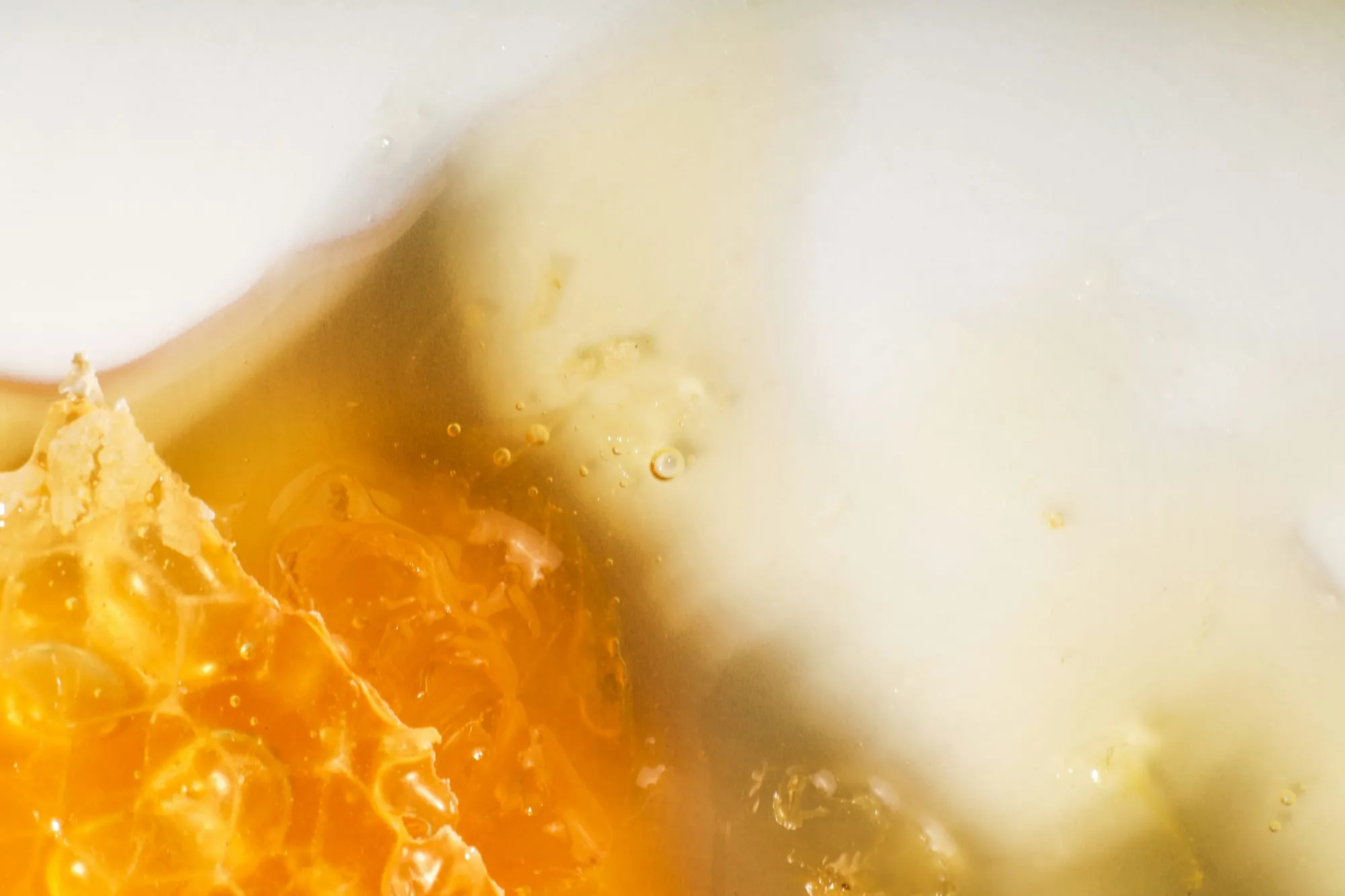 Goldener Honig mit Wabe in Nahaufnahme